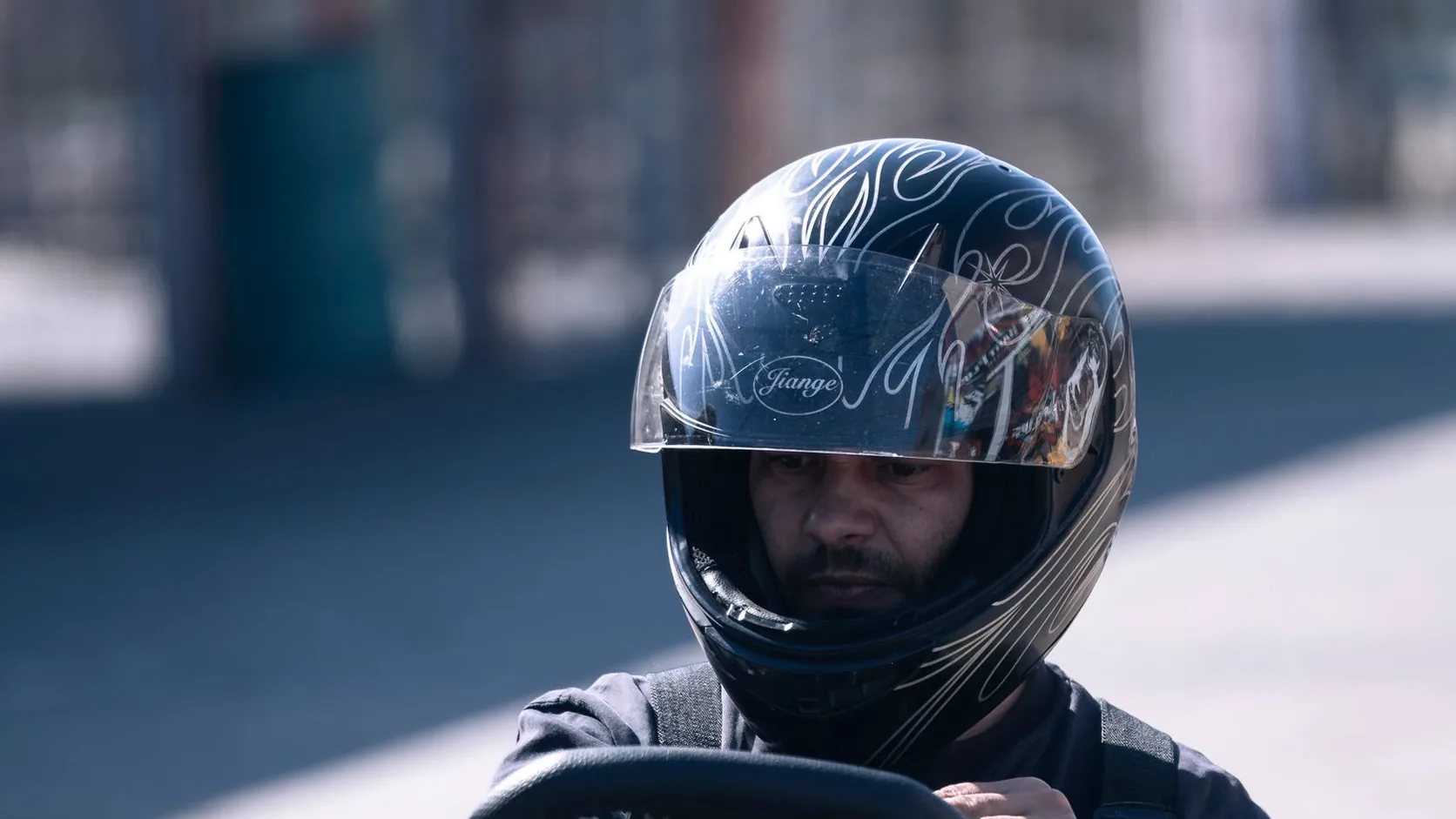 Kart driver in a full-face helmet sitting in a racing kart before a session